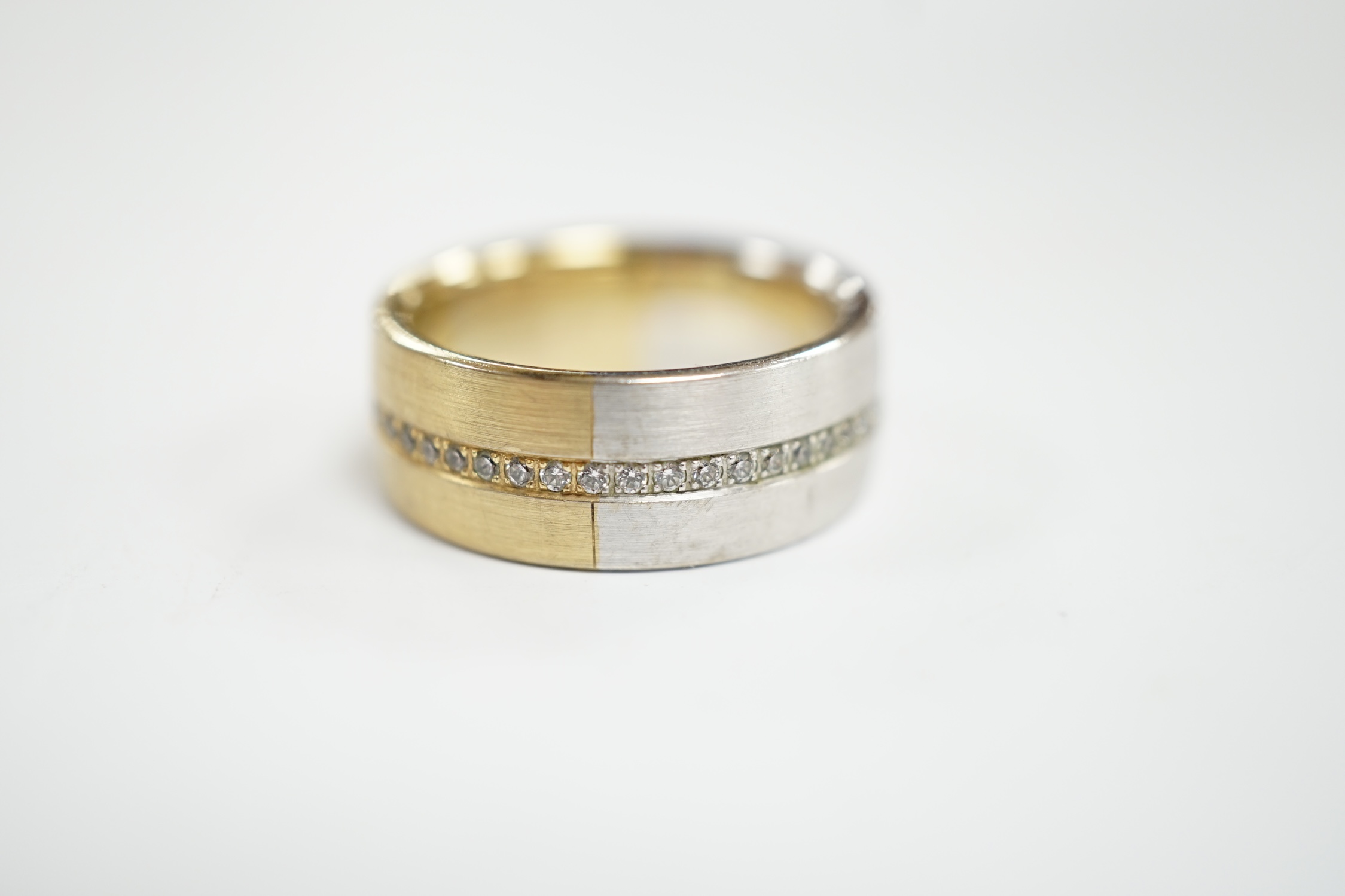 A two colour base metal band, with central row of simulated diamonds, size O.